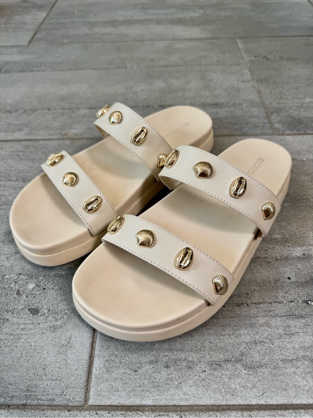 BCBGeneration Cream Slide Sandals with Gold Shell Accents